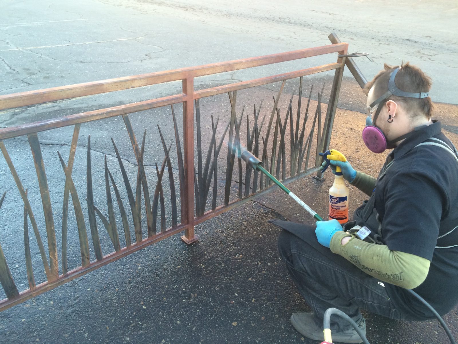 DiMasi fabricator grinding a custom steel railing in the Denver shop
